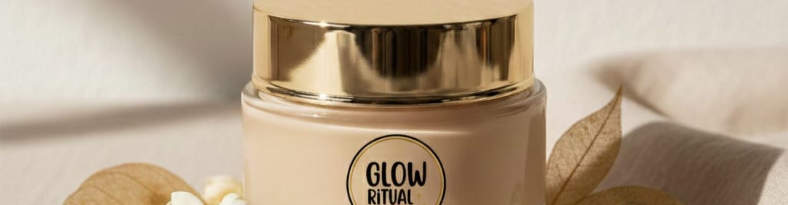 Luxury skincare hero image for a premium face mask brand called “Glow Ritual”, minimalist aesthetic, elegant glass face mask jar placed at center, soft creamy mask texture visible inside the jar, subtle botanical elements around the product, neutral color palette with beige, ivory, and soft gold tones, clean background, spa-inspired mood, natural diffused lighting, high-end beauty editorial photography, shallow depth of field, ultra-realistic, calm and glowing atmosphere,